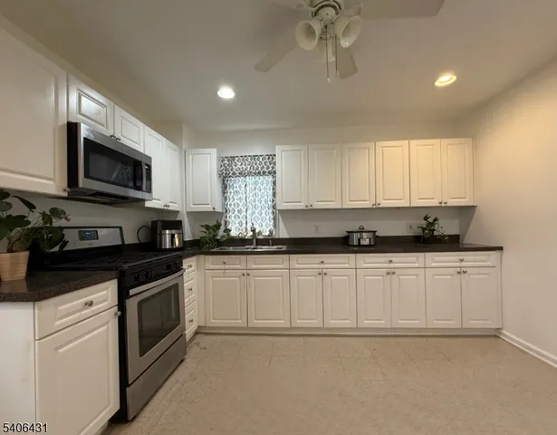 a kitchen with stainless steel appliances white cabinets and a refrigerator