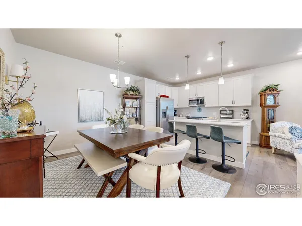 a living room with furniture kitchen view and a chandelier