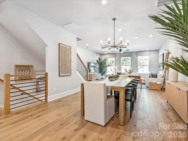 a dining room with wooden floor a chandelier a wooden table and chairs