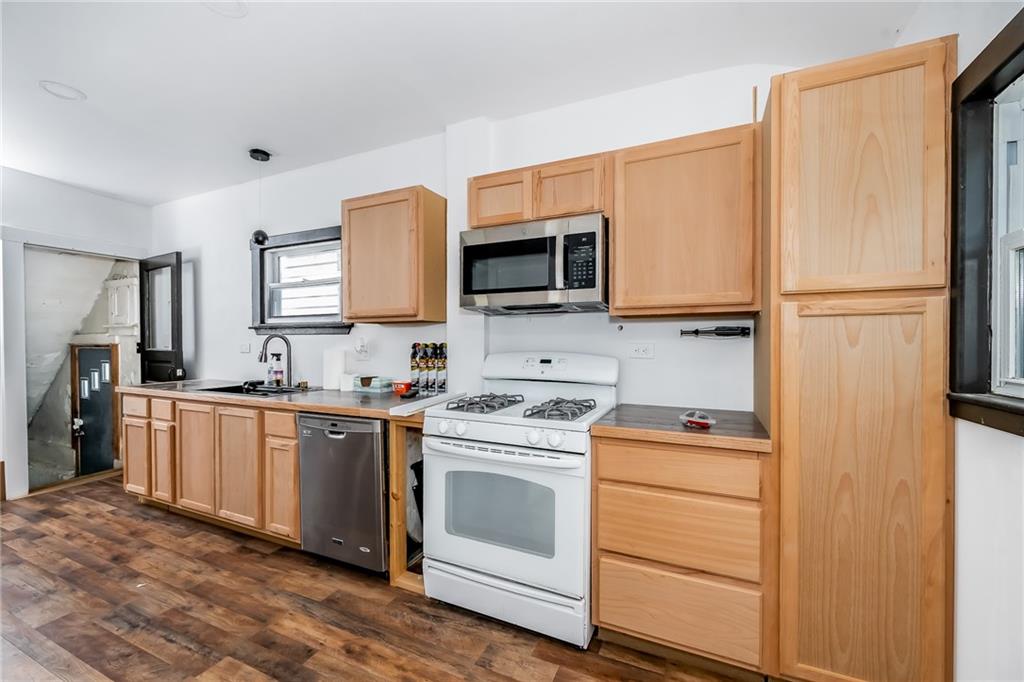 925 Roup Avenue Brackenridge, PA 15014 - Photo 11 of 28 a kitchen with stainless steel appliances granite countertop a stove top oven a refrigerator and a microwave oven
