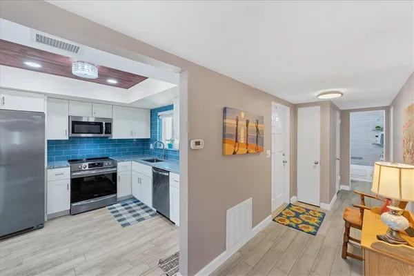 a kitchen with a sink cabinets and wooden floor
