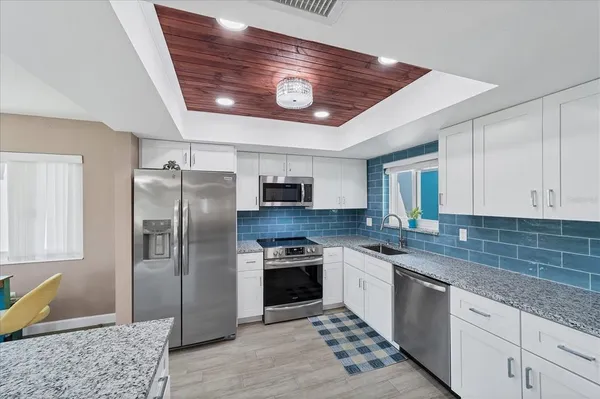 a kitchen with stainless steel appliances granite countertop a stove refrigerator and microwave