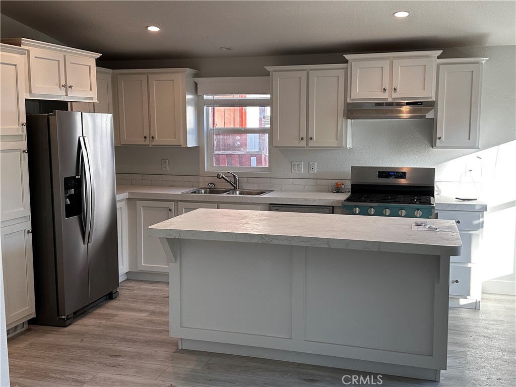 21845 Grand Terrace Road, Unit 12 Grand Terrace, CA 92313 - Photo 5 of 7 a kitchen with kitchen island granite countertop a refrigerator and a sink
