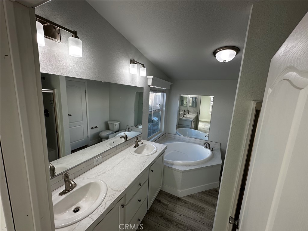 21845 Grand Terrace Road, Unit 12 Grand Terrace, CA 92313 - Photo 7 of 7 a bathroom with a double vanity sink and mirror with shower