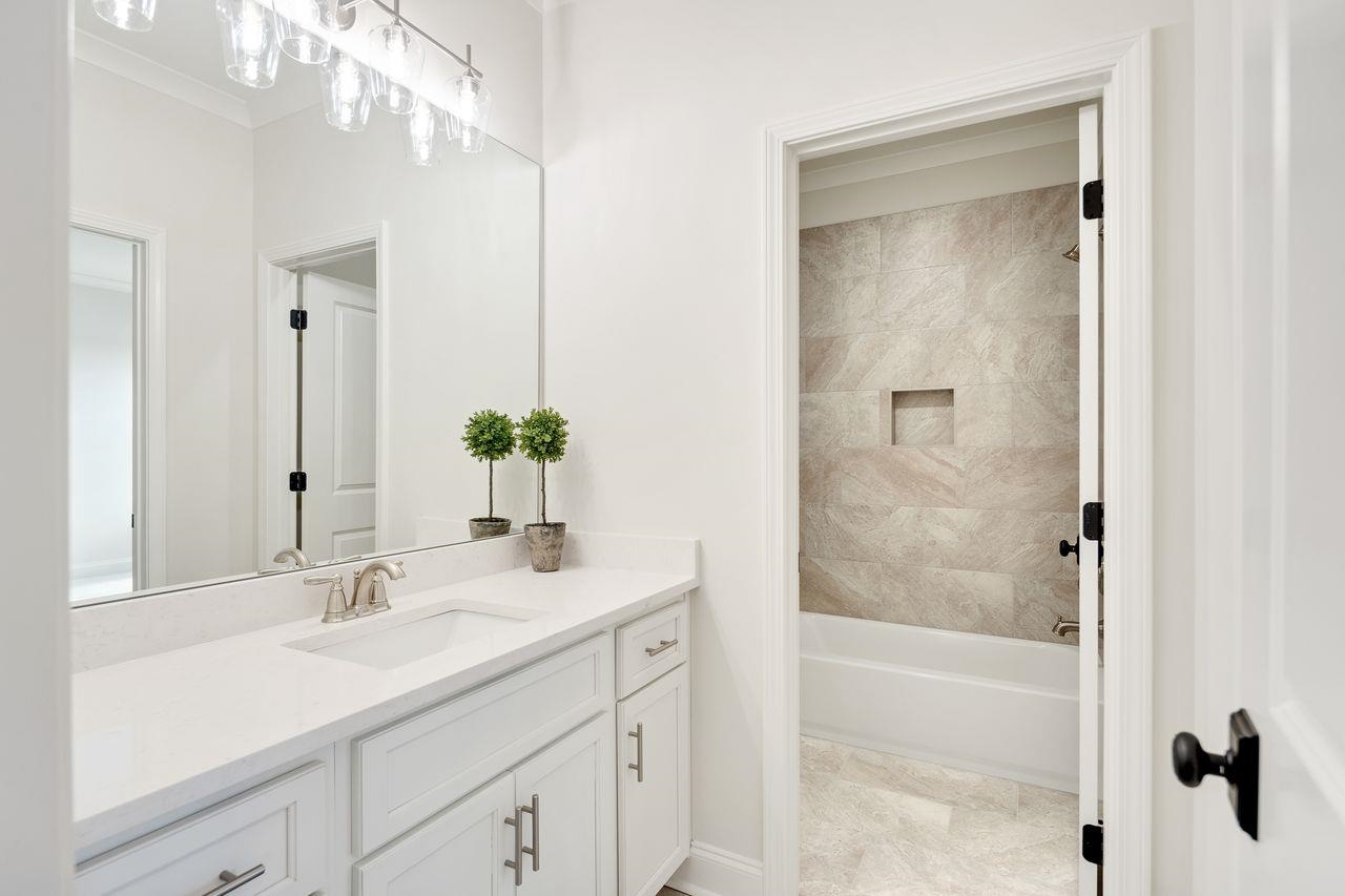 606 Cedar Shadows Circle West Collierville, TN 38017 - Photo 28 of 35 a bathroom with a granite countertop sink a mirror and a bathtub