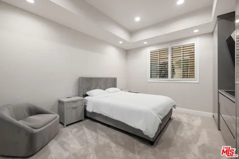 a bedroom with a bed couch and a large window