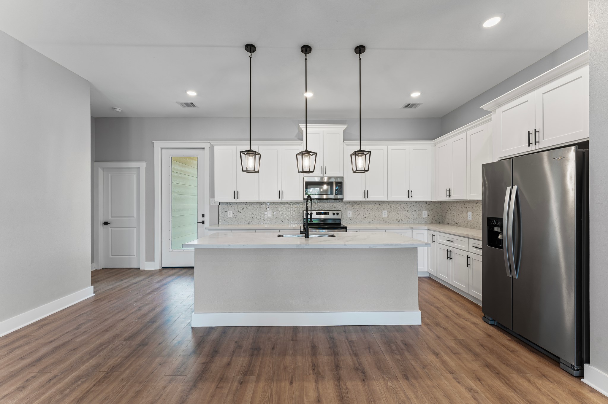 1218 Peter Pine Street Huffman, TX 77336 - Photo 2 of 9 a large kitchen with stainless steel appliances a large counter top a sink a refrigerator and a window