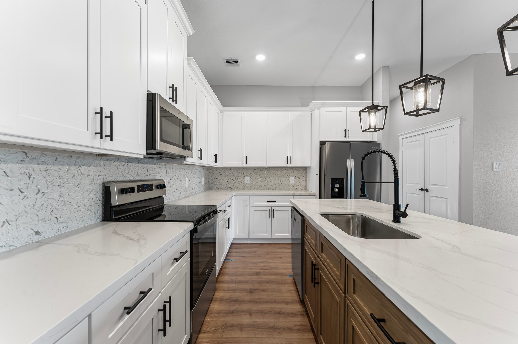1218 Peter Pine Street Huffman, TX 77336 - Photo 3 of 9 a kitchen with stainless steel appliances granite countertop a sink a stove and a microwave with wooden floor