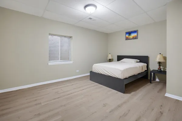 a white bed sitting in a bedroom next to a window