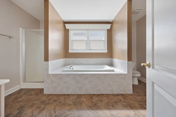 a view of bathroom with bathtub and window