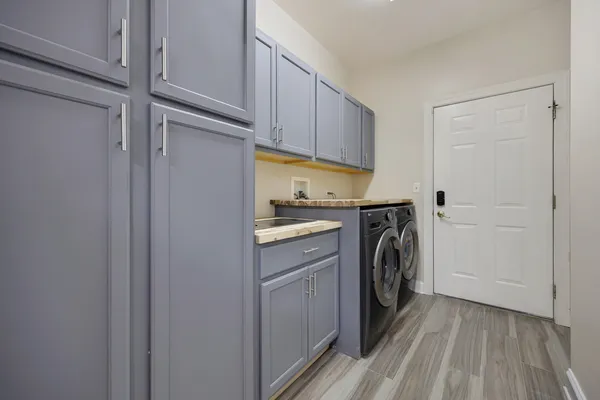 a utility room with cabinets washer and dryer