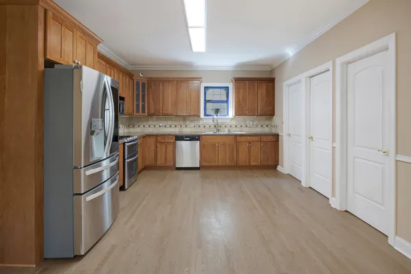 a kitchen with stainless steel appliances granite countertop a refrigerator and a stove