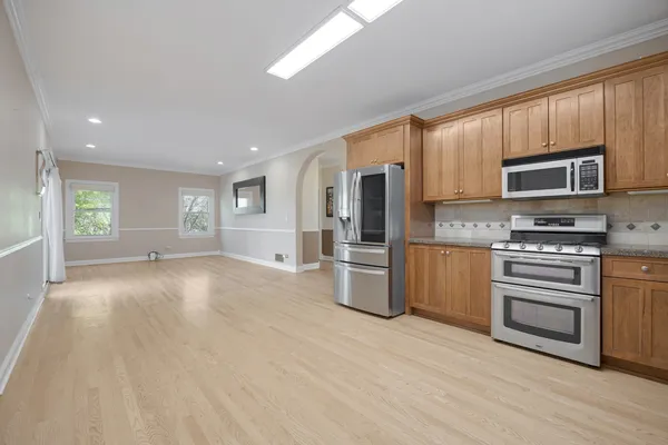 a view of kitchen with stainless steel appliances wooden cabinets and entryway