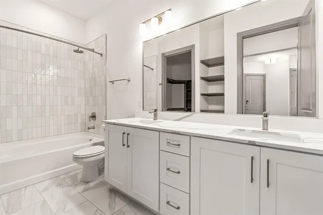 a bathroom with a double vanity sink toilet and shower