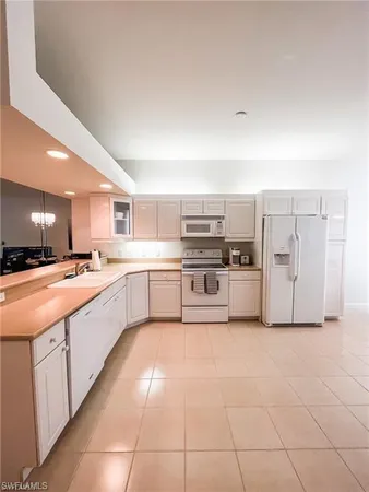 a large white kitchen with cabinets and stainless steel appliances