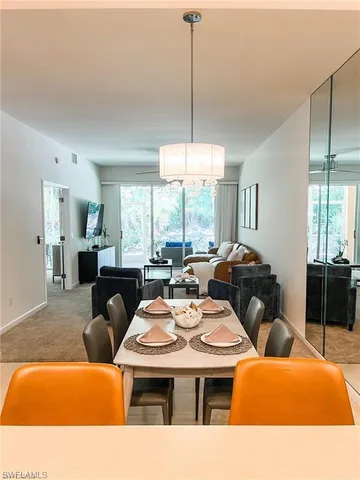 a living room with furniture a chandelier and a large window