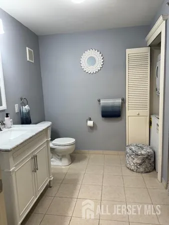 a spacious bathroom with a granite countertop sink a toilet and a mirror
