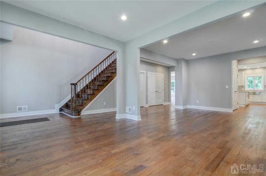 127 North Hill Road Colonia, NJ 07067 - Photo 11 of 40 a view of an empty room with wooden floor stairs and a way to kitchen