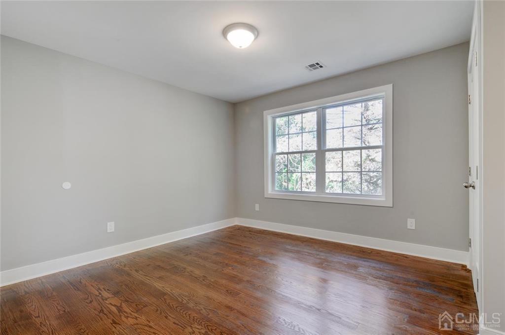 127 North Hill Road Colonia, NJ 07067 - Photo 29 of 40 an empty room with wooden floor and windows
