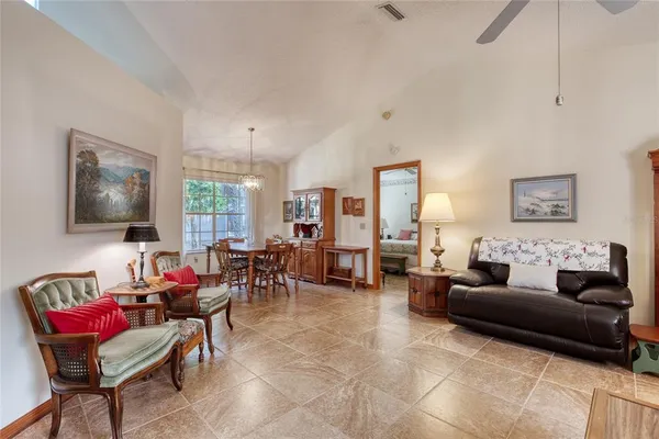 a living room with furniture a flat screen tv and a large window