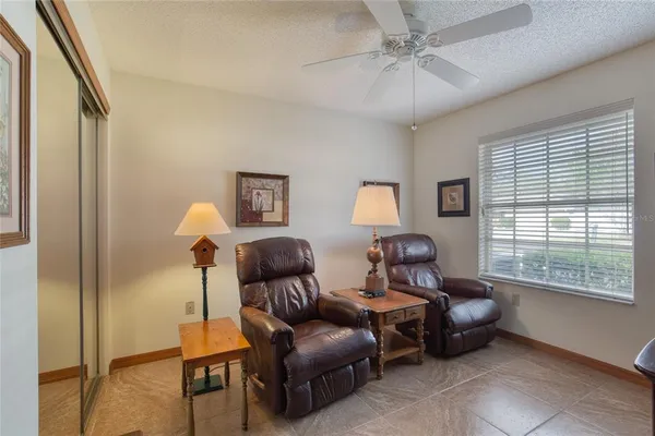 a living room with furniture a rug and a floor to ceiling window