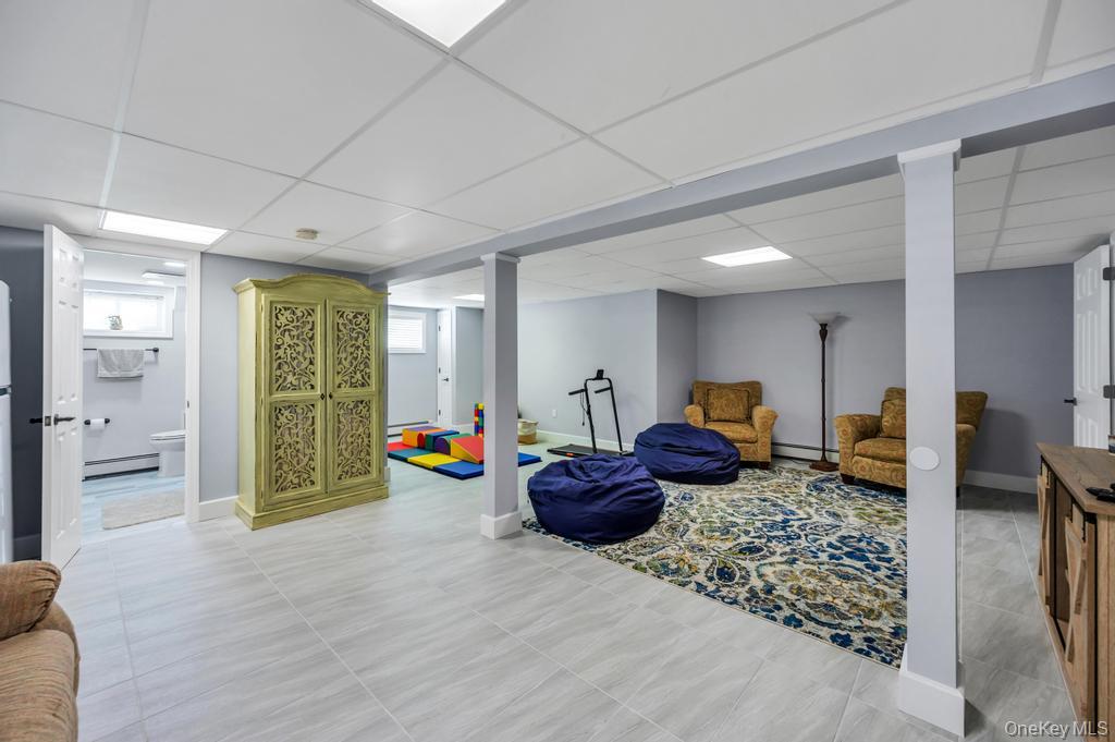 10 South Lot Road Smithtown, NY 11787 - Photo 31 of 50 Finished lower level featuring recessed lighting, light gray wall paint, light-toned tile flooring, and a full bathroom with a window