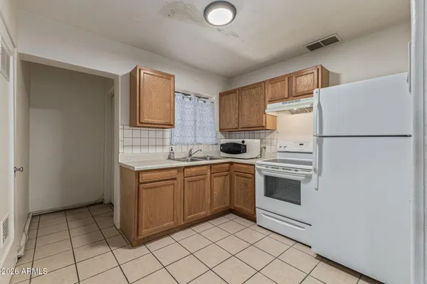 a kitchen with cabinets and white appliances