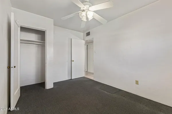 an empty room with a ceiling fan and a fan