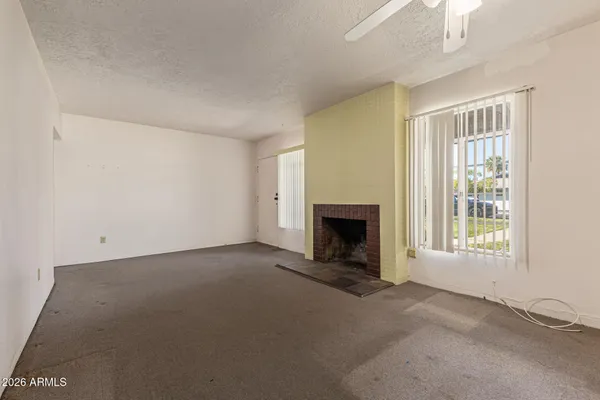 an empty room with a fireplace and window
