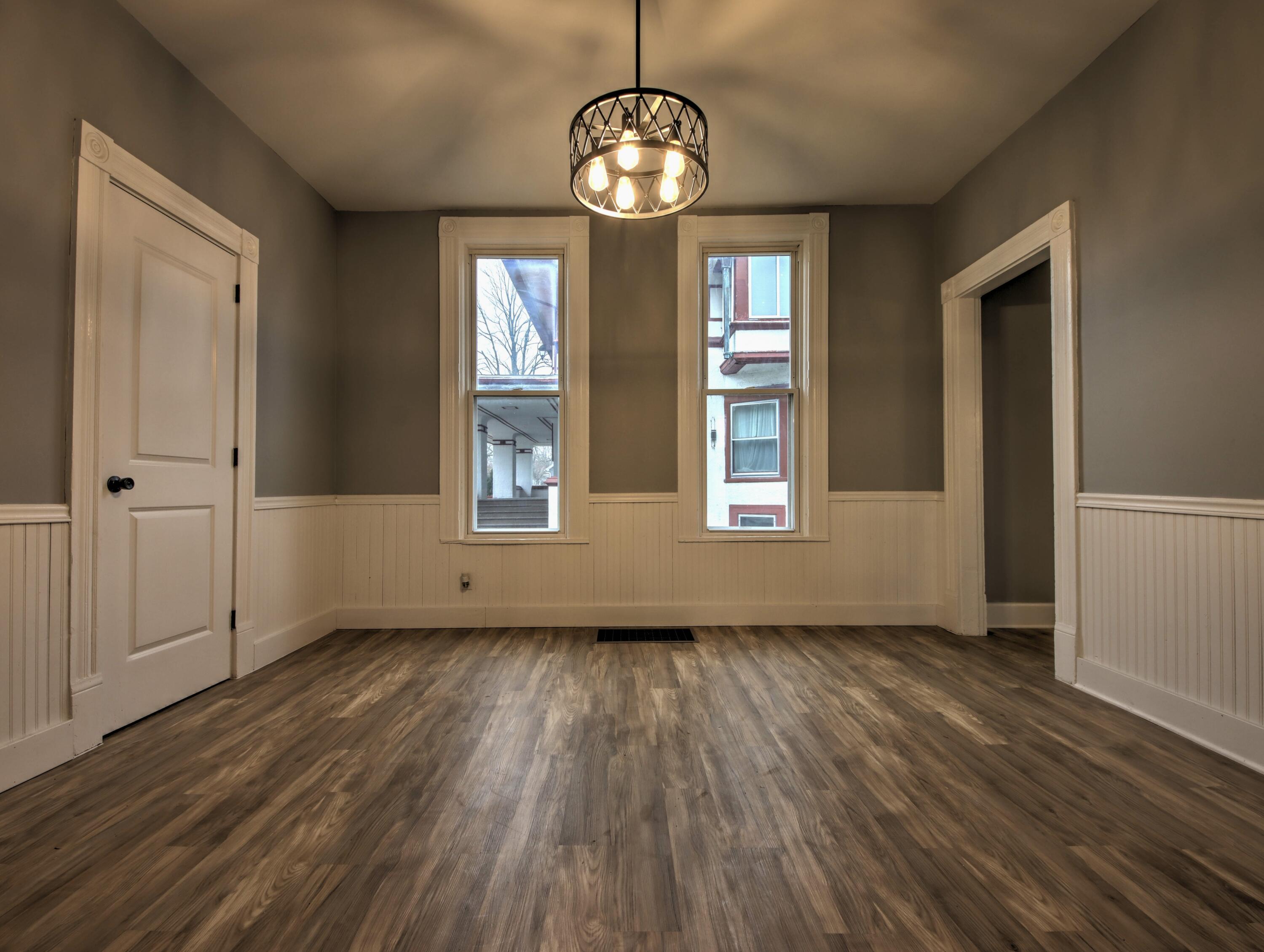 1005 Harrison Street La Porte, IN 46350 - Photo 13 of 54 an empty room with wooden floor chandelier and windows