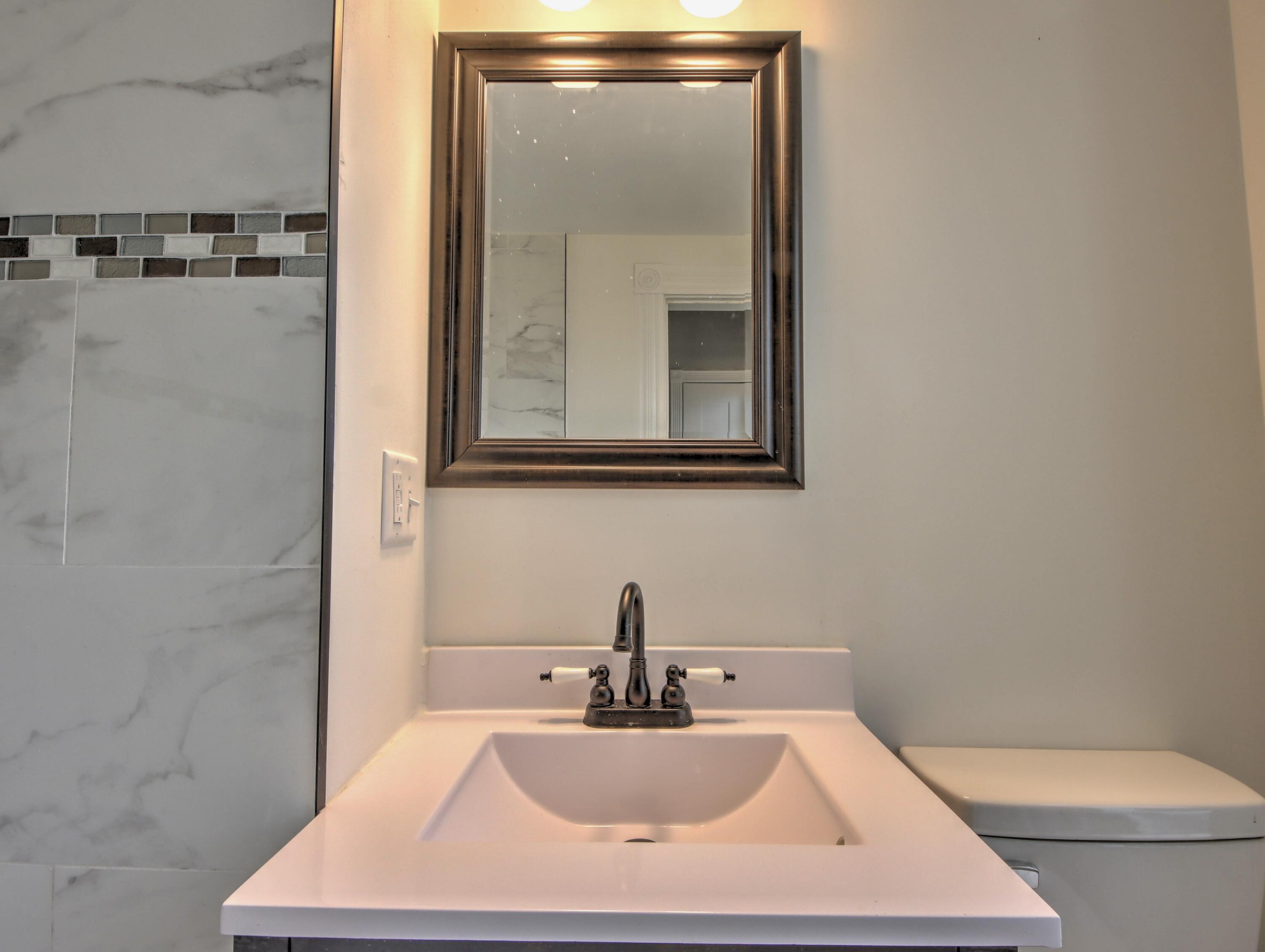 1005 Harrison Street La Porte, IN 46350 - Photo 22 of 54 a bathroom with a toilet sink and mirror