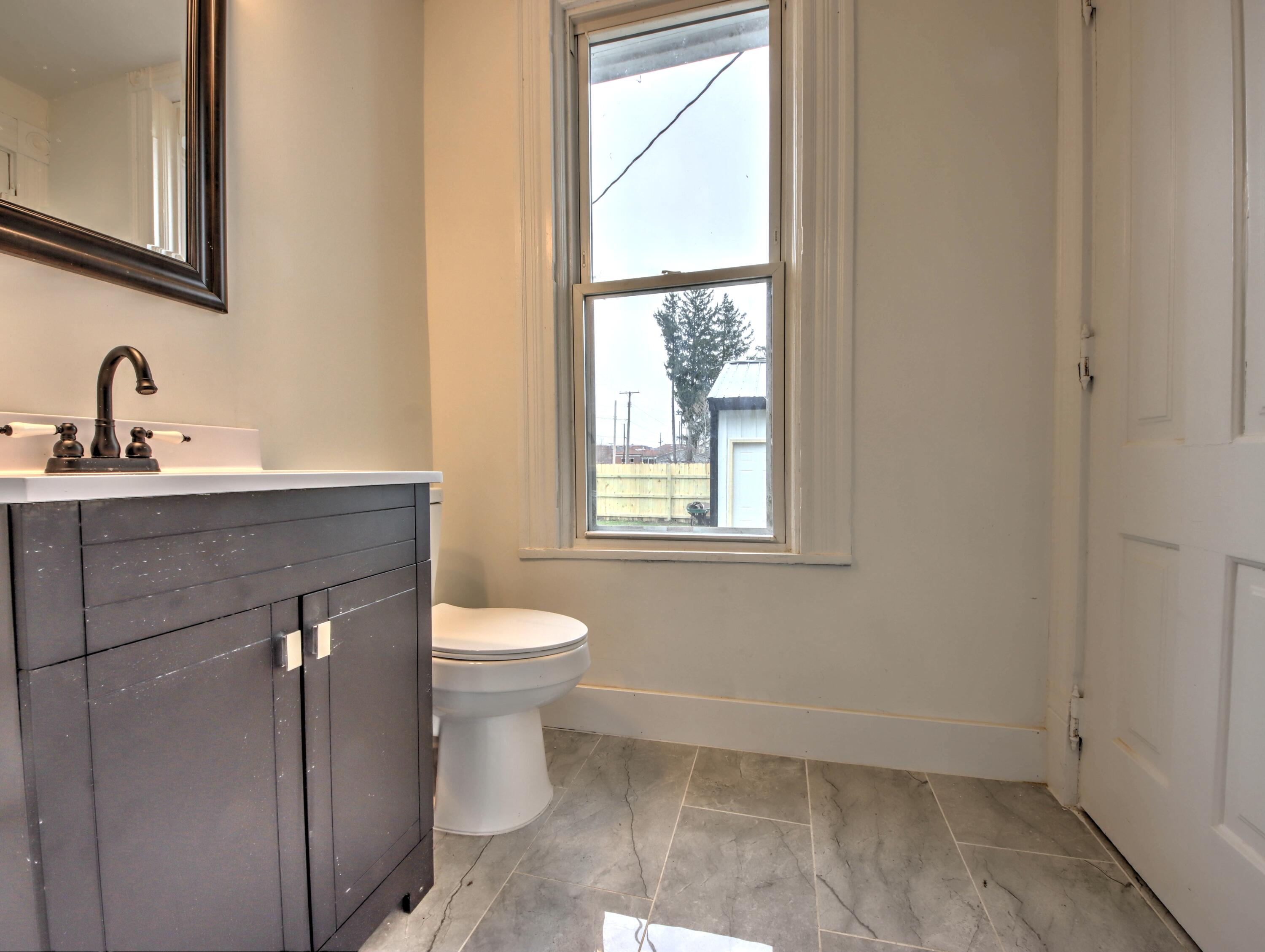 1005 Harrison Street La Porte, IN 46350 - Photo 24 of 54 a bathroom with a sink a toilet and a window