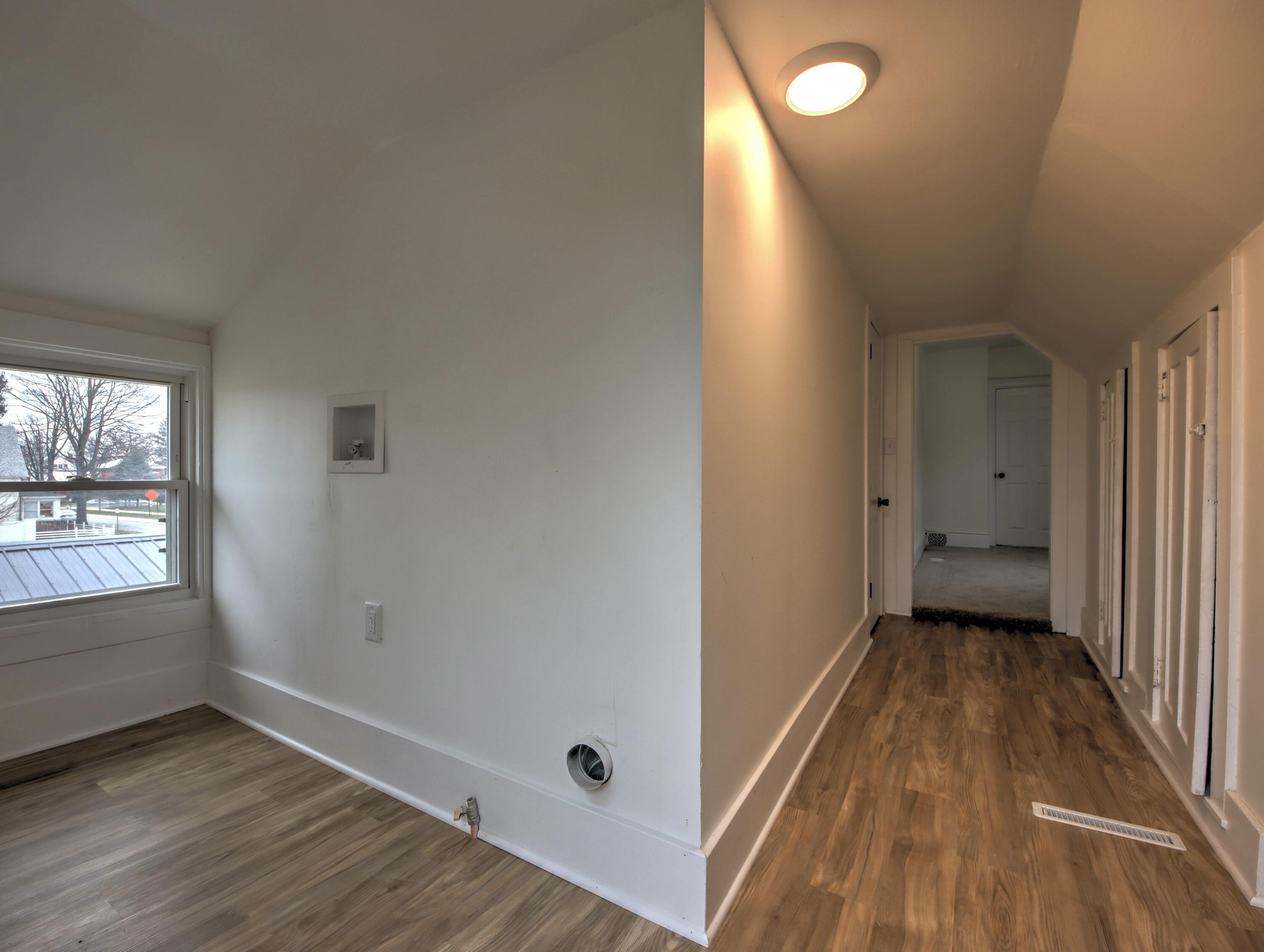 1005 Harrison Street La Porte, IN 46350 - Photo 39 of 54 a view of a hallway with wooden floor and a bathroom