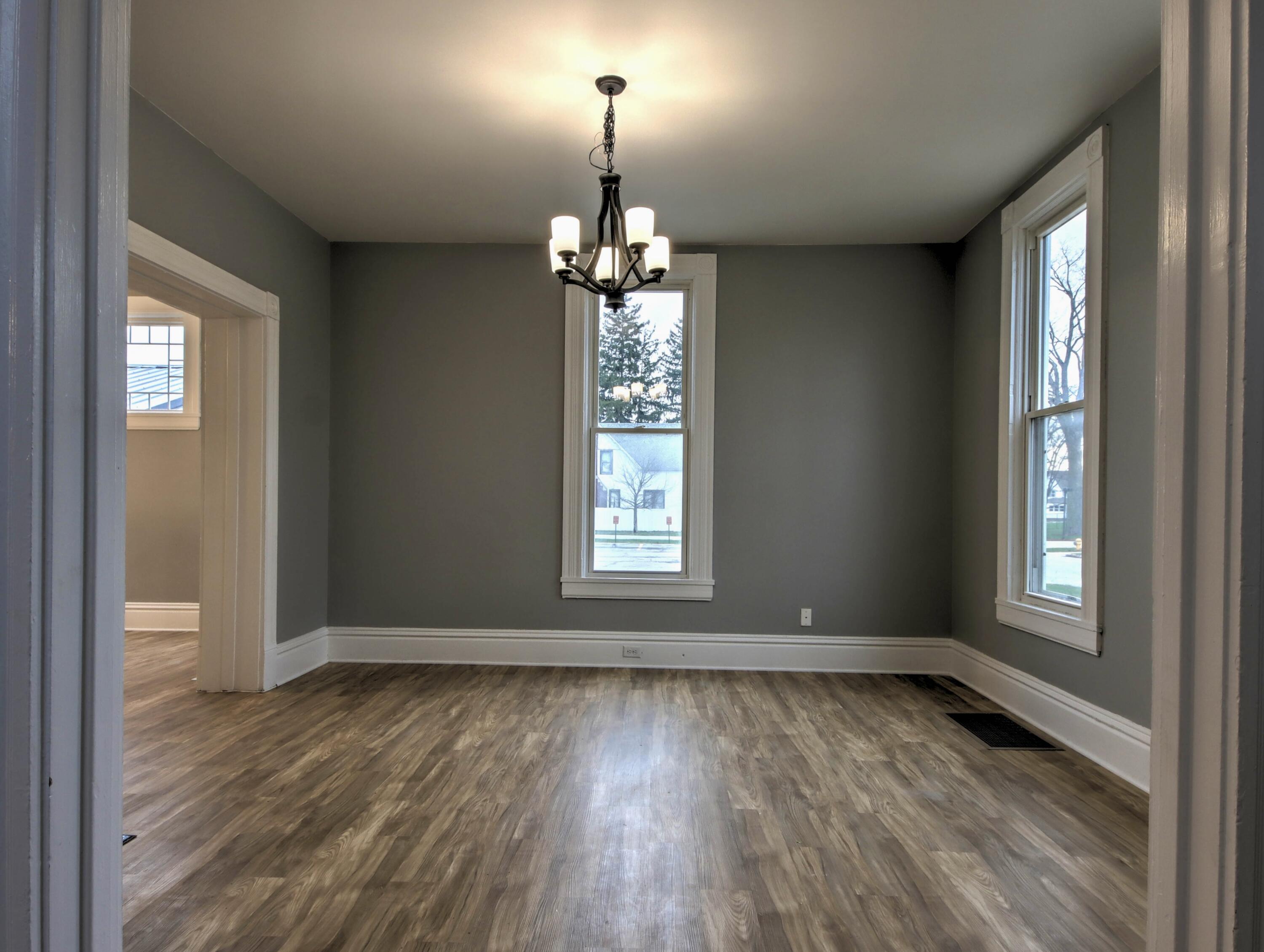 1005 Harrison Street La Porte, IN 46350 - Photo 6 of 54 an empty room with wooden floor chandelier and windows