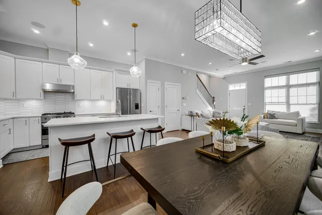 a view of a a dining room with furniture a chandelier and wooden floor