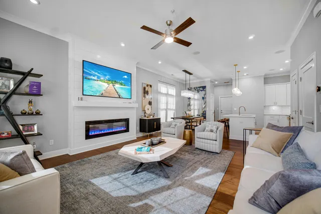 a living room with furniture kitchen view and a chandelier