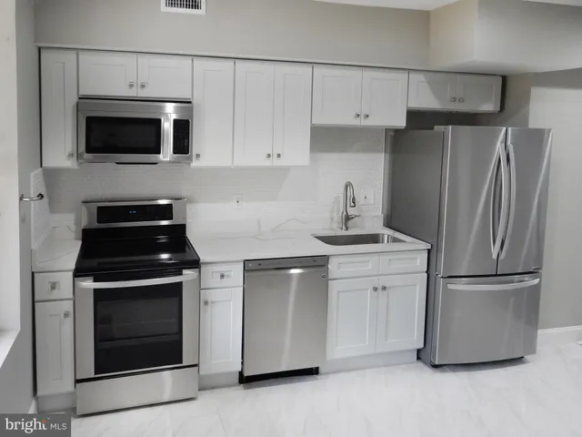 a kitchen with stainless steel appliances white cabinets and a stove