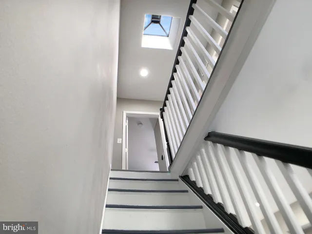 a view of staircase with railing and white walls