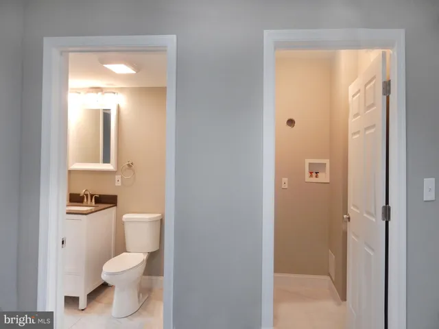 a bathroom with a toilet sink vanity and mirror