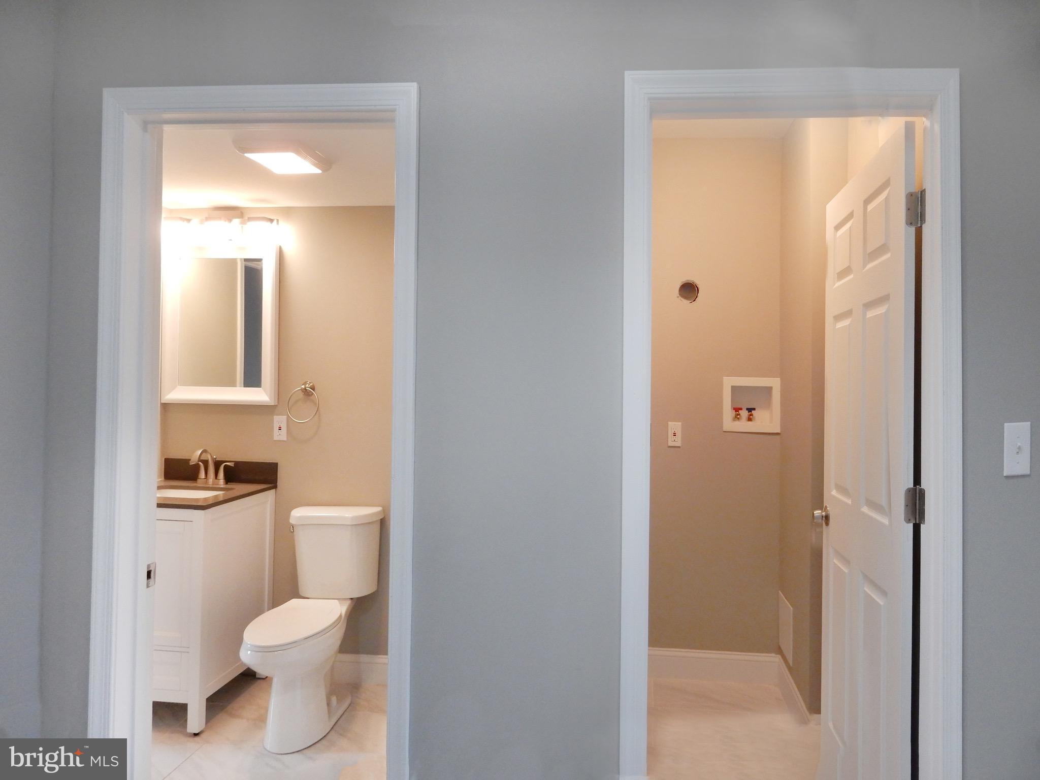 1111 Bayard Street Baltimore, MD 21223 - Photo 20 of 39 a bathroom with a toilet sink vanity and mirror