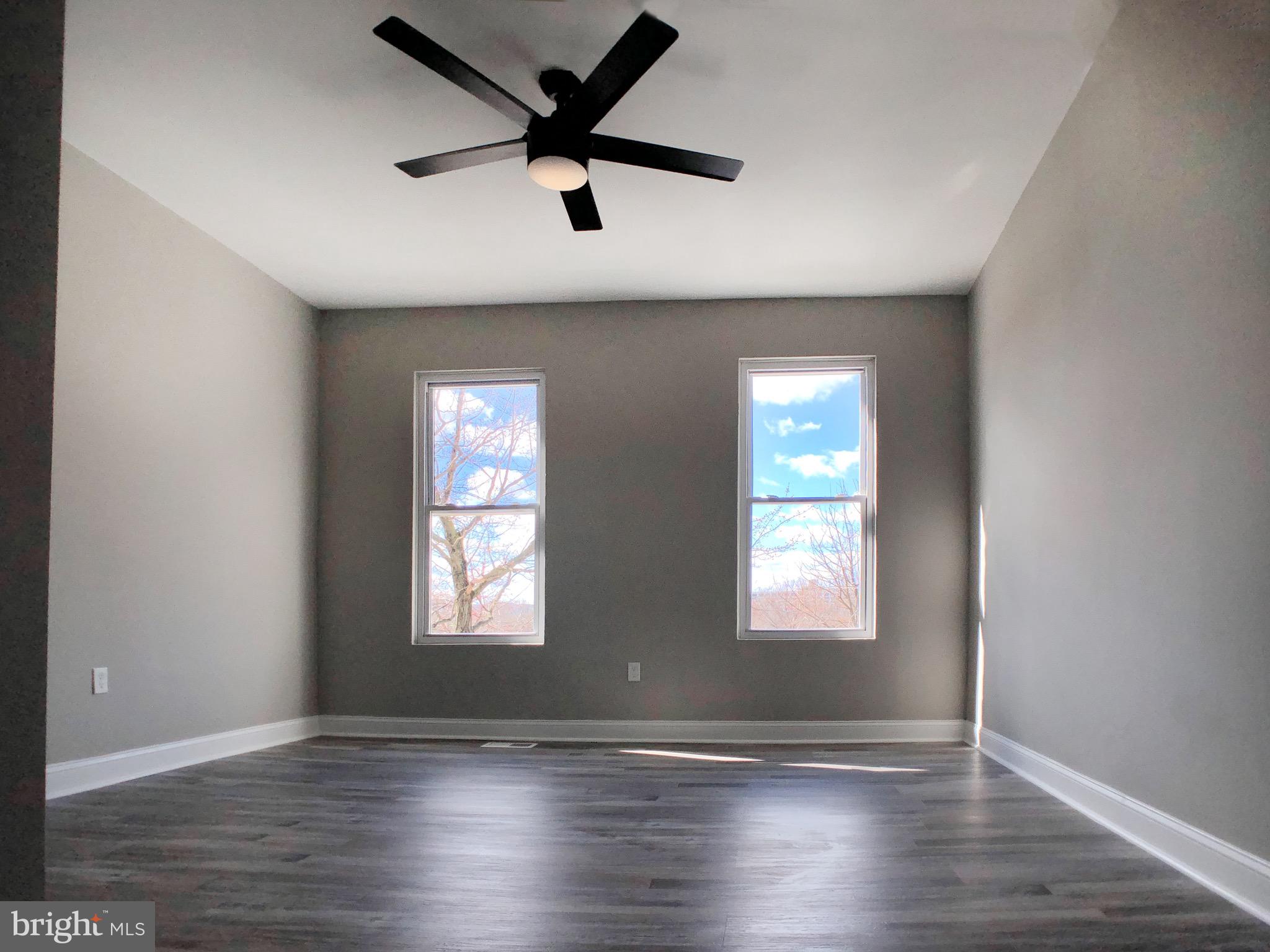 1111 Bayard Street Baltimore, MD 21223 - Photo 24 of 39 an empty room with wooden floor and windows