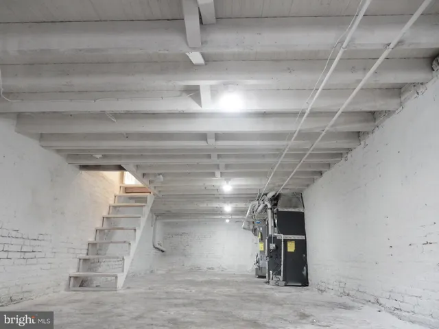 a view of kitchen with stainless steel appliances wooden floor and window