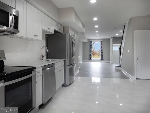 a kitchen with stainless steel appliances a refrigerator a stove a microwave and cabinets
