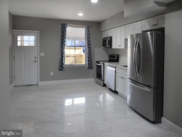 a kitchen with stainless steel appliances white cabinets and a refrigerator