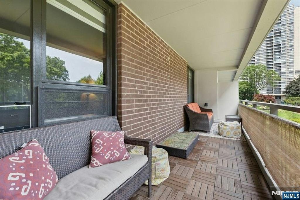 2 Horizon Road, Unit G1 Fort Lee, NJ 07024 - Photo 16 of 44 a balcony with wooden floor and glass top table