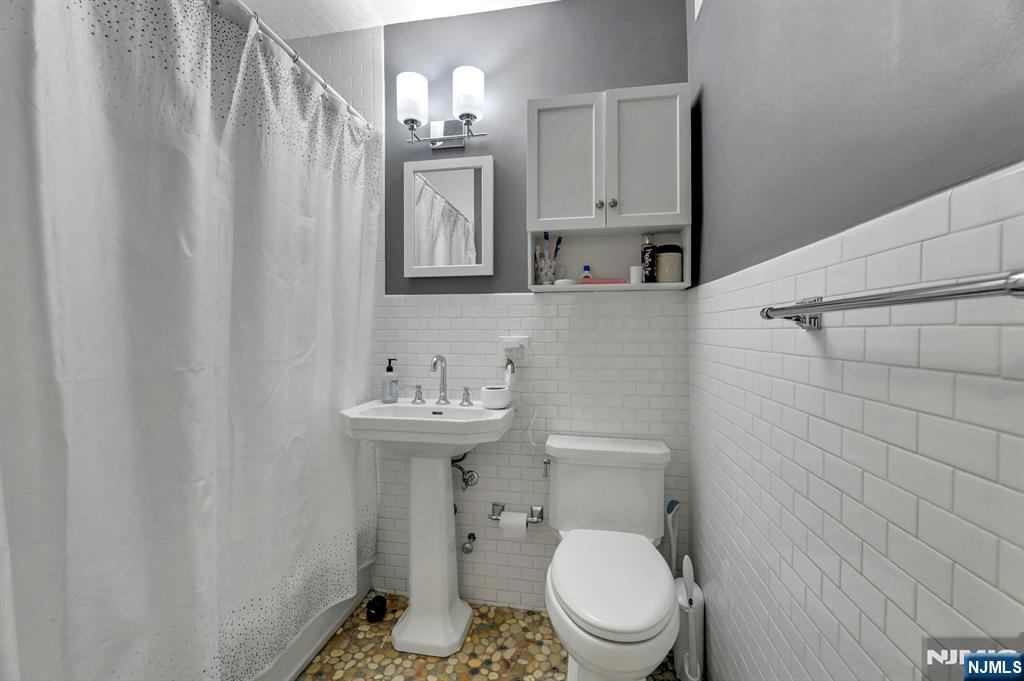 2 Horizon Road, Unit G1 Fort Lee, NJ 07024 - Photo 28 of 44 a bathroom with a toilet a sink and mirror