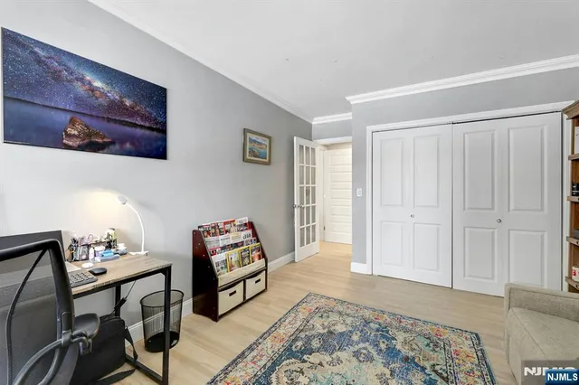 a bedroom with a bed and a flat tv screen on the dresser