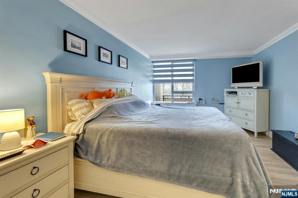 2 Horizon Road, Unit G1 Fort Lee, NJ 07024 - Photo 36 of 44 a bedroom with a bed and a flat tv screen on the dresser