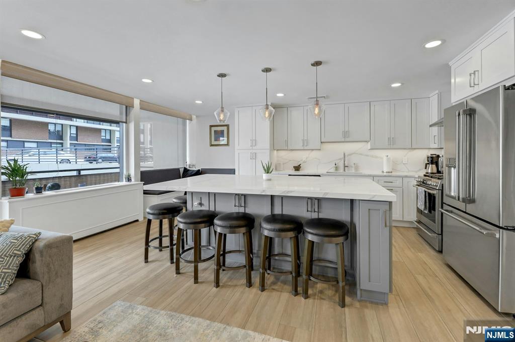 2 Horizon Road, Unit G1 Fort Lee, NJ 07024 - Photo 8 of 44 a kitchen with granite countertop a table chairs stove a refrigerator and a living room view