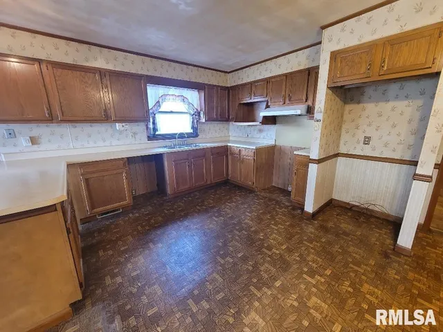 a kitchen with stainless steel appliances granite countertop a sink a stove a refrigerator cabinets and wooden floor